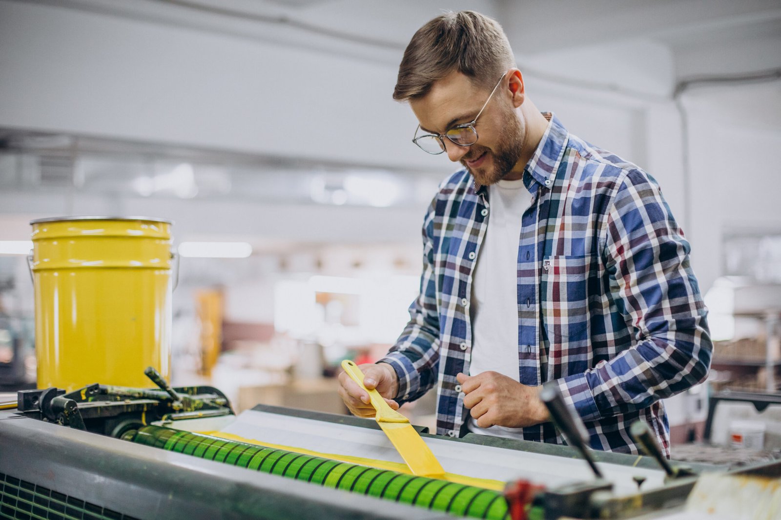 man working in printing house with paper and paints